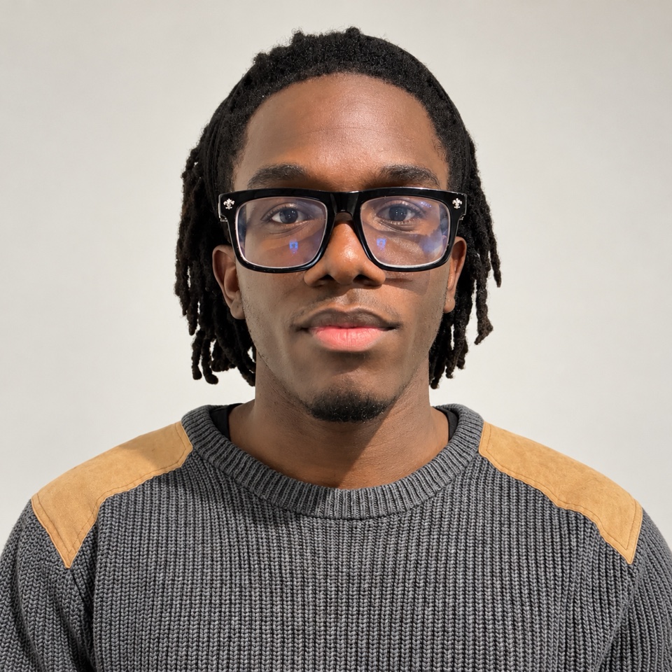 Portrait of Alexander Ayeye wearing glasses and a gray sweater